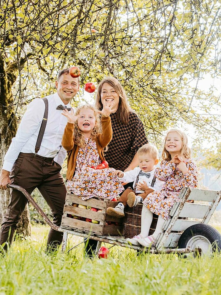 Familie Arnegger mit Kindern und Schubkarre auf dem Feld