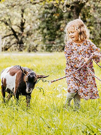 Kind mit Ziege auf dem Feld